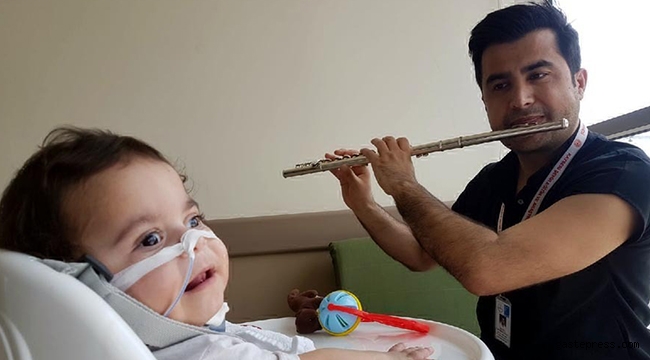 Hem tedavi ediyor hem flüt çalarak moral veriyor!